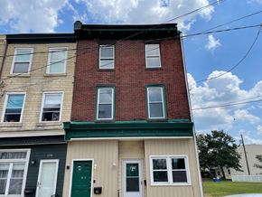 Gloucester City apartment for rent - Three story building with red brick and green trim.