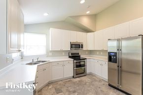 Thornton house for rent - a white kitchen with stainless steel appliances and white cabinets