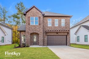 Odenville house for rent - A brick house with a garage door and a window.