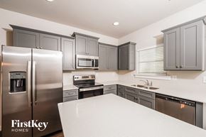 Odenville house for rent - A kitchen with a refrigerator, microwave, oven, and sink.