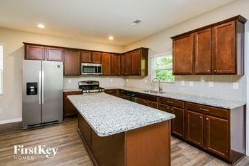 Dawsonville house for rent - a kitchen with wooden cabinets and granite counter tops and a stainless steel refrigerator