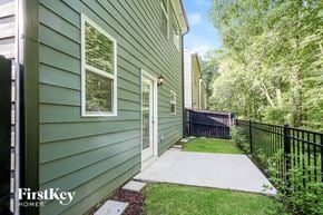 Dawsonville house for rent - the walkway to the front door of a green house with a black fence