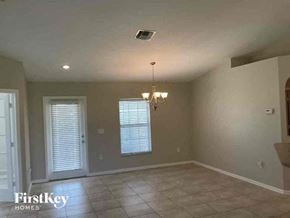 Cape Coral house for rent - A room with a chandelier and a window with blinds.