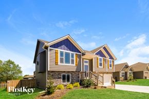 Raymore house for rent - a home with a stone exterior and a blue roof
