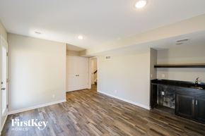 Raymore house for rent - a living room and kitchen with wood flooring and white walls