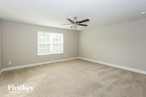 Statesville house for rent - a bedroom with carpet and a ceiling fan