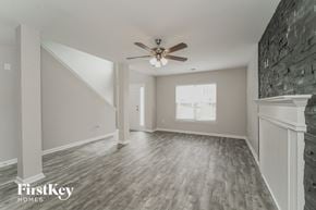 Kannapolis house for rent - A spacious room with a ceiling fan and wooden flooring.