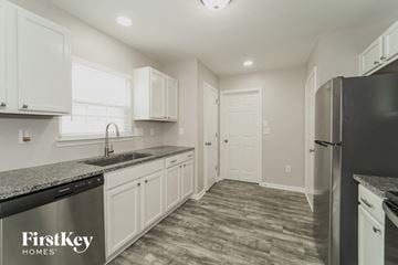 Kannapolis house for rent - A kitchen with a black fridge and a sink with a black dishwasher.
