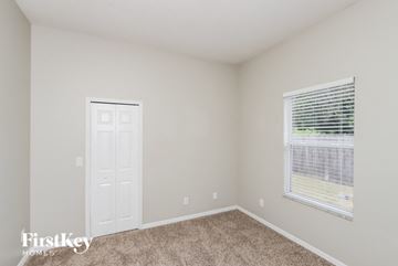 Melbourne house for rent - a bedroom with a window and a white door and carpet
