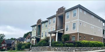 Atlanta apartment for rent - A large apartment building with a stone wall in front.