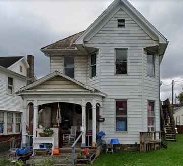 Zansville apartment for rent - a white house with a porch on a cloudy day