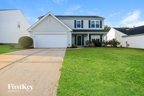 Charlotte house for rent - a white house with a driveway and a lawn