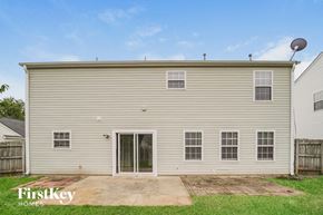 Charlotte house for rent - the exterior of a white house with a patio and grass