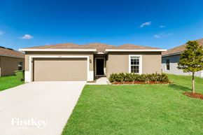 Winter Haven house for rent - a beige house with a driveway and a garage door