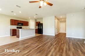 Winter Haven house for rent - an empty living room with a kitchen and a ceiling fan