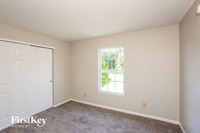 Noblesville house for rent - A room with a white door and a window with a view of trees.