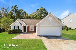 Charlotte house for rent - a white house with a white garage door and a lawn