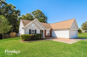 Charlotte house for rent - a small white house with a lawn and a driveway