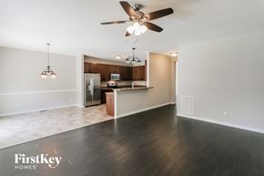 Lake St Louis house for rent - an empty living room and kitchen with a ceiling fan