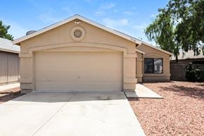 Phoenix house for rent - a beige house with a garage door and a driveway