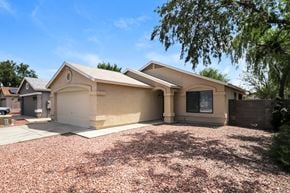 Phoenix house for rent - a beige house with a driveway and a tree