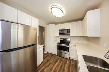 Phoenix house for rent - a kitchen with stainless steel appliances and white cabinets