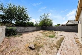Phoenix house for rent - a backyard with a brick retaining wall and dirt and grass