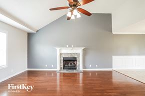 Clarksville house for rent - A spacious living room with a fireplace and a ceiling fan.