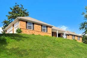 St Louis house for rent - a brick house on top of a grass covered hill