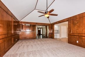 St Louis house for rent - an empty living room with wooden cabinets and a ceiling fan
