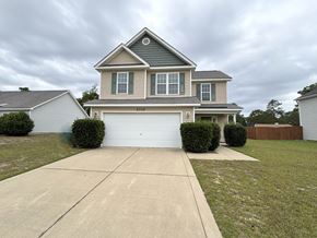 Hope Mills house for rent - A two-story house with a garage is surrounded by a well-maintained lawn and a sidewalk.