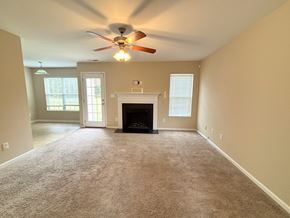 Hope Mills house for rent - A living room with a fireplace and a ceiling fan.