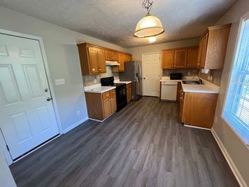 Fayetteville house for rent - a kitchen with wood floors and wooden cabinets