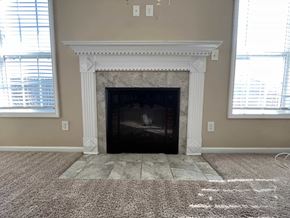 Hope Mills house for rent - the living room has a fireplace and a carpeted floor