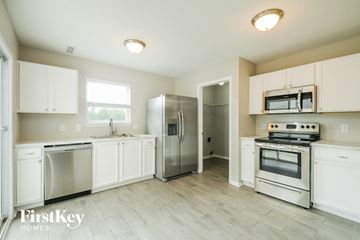 Noblesville house for rent - a kitchen with white cabinets and stainless steel appliances
