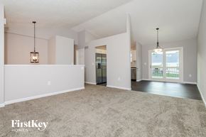 Cincinnati house for rent - A spacious living room with a carpeted floor and a large window.