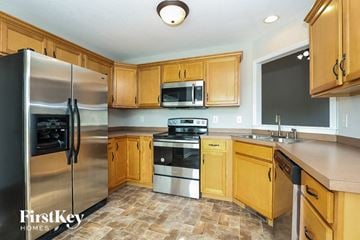 Clarksville house for rent - a kitchen with stainless steel appliances and wooden cabinets