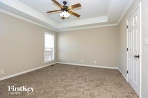 Clarksville house for rent - the master bedroom has a ceiling fan and a carpeted floor