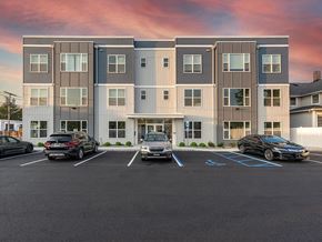 Atlantic Highlands apartment for rent - an apartment building with cars parked in a parking lot