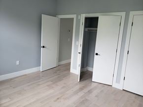 Newark apartment for rent - a bedroom with three closet doors and a wood floor