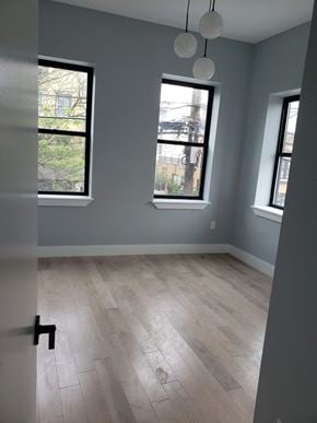Newark apartment for rent - a room with a hard wood floor and three windows