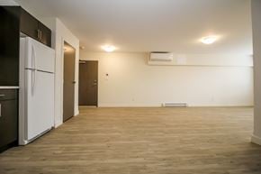 Brandon apartment for rent - A kitchen with a white fridge and wooden floors.