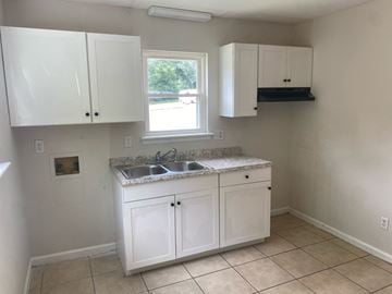 Monroe apartment for rent - an empty kitchen with white cabinets and a sink