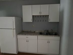 Monroe apartment for rent - an empty kitchen with white cabinets and a refrigerator