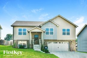 Clarksville house for rent - a beige house with a garage and a green lawn