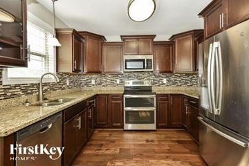 Clarksville house for rent - a kitchen with wooden cabinets and granite counter tops and stainless steel appliances