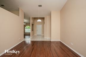 Clearwater house for rent - A large empty room with wooden floors and a doorway leading to another room.