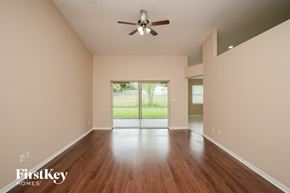 Clearwater house for rent - A room with a ceiling fan and wooden floors.