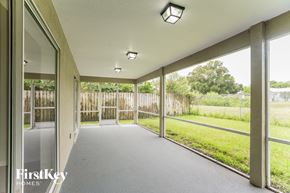 Clearwater house for rent - A long hallway with a view of a fence and trees outside.