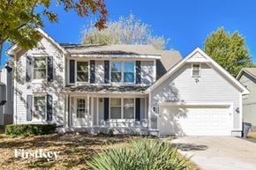 Olathe house for rent - a white house with a white garage and a tree